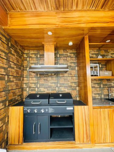 a stove in a kitchen with a brick wall at Host Homes San Gerardo in Tacloban