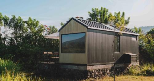 a small house with a large window in a field at Bobocabin Gunung Rinjani, Lombok in Sembalun Lawang