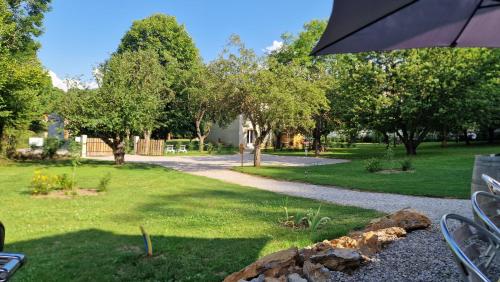 a view of a garden with an umbrella at Gîte l'Enclos Ô rendez-vous Roquefeuil-Pays de sault- avec jardin in Roquefeuil