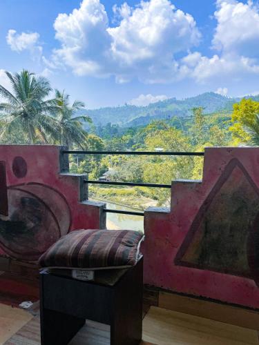 a balcony with a bench and a view of the mountains at New Uduwara Guest in Ella