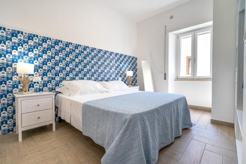 a bedroom with a bed and a blue and white wall at B&B Sperlonga in Sperlonga