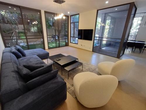 a living room with a couch and a table and chairs at Super house- villa09 in Hod HaSharon
