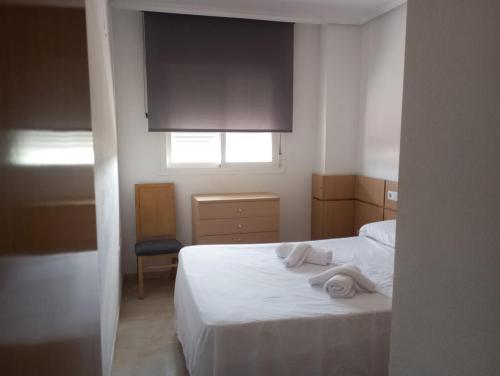 a bedroom with a white bed with towels on it at Torre la Sal - Edificio Mediterráneo 1- Vistas al parque natural in Cabanes