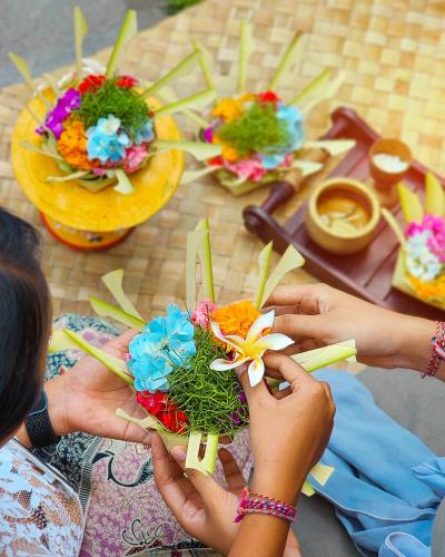 a group of people holding flowers on a table at tanadewa Resort Ubud Bali by Cross Collection in Ubud