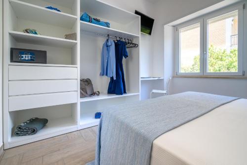 a white bedroom with a bed and a window at B&B Sperlonga in Sperlonga
