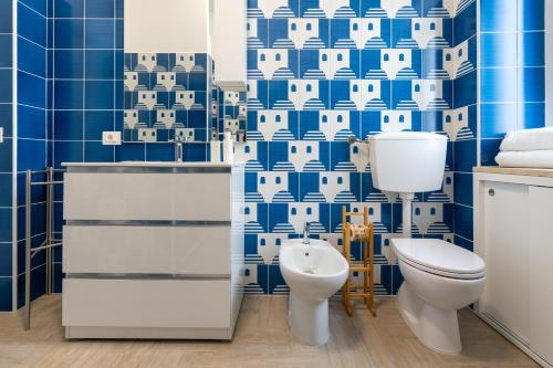a bathroom with a toilet and blue tiles at B&B Sperlonga in Sperlonga