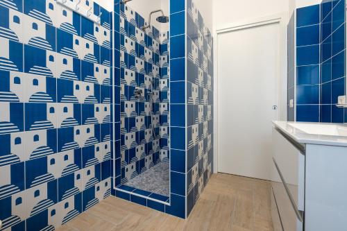 a bathroom with a blue and white tile wall at B&B Sperlonga in Sperlonga