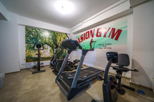 a gym with three treadmills and a sign on the wall at Asion Lithos in Kato Asites