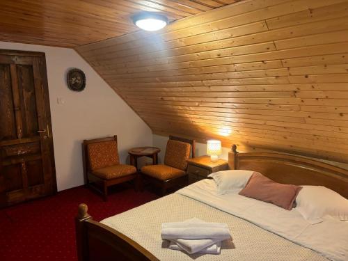 a bedroom with a bed and a wooden ceiling at Chalet Milenium Residence Bran in Bran