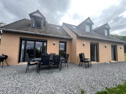 une table et des chaises devant une maison dans l'établissement les hauts du lac, à Éguzon-Chantôme