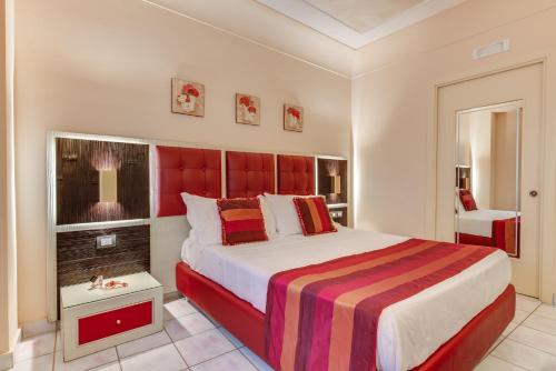 a bedroom with a large bed with a red headboard at Fazio Rooms in Sciacca