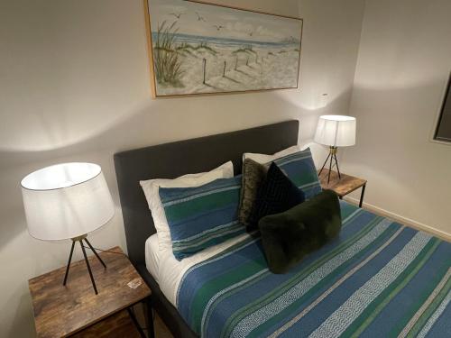 a bedroom with a bed with pillows and two lamps at Flat Bush Holiday Accomodation in Auckland