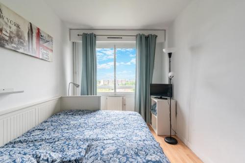 ein Schlafzimmer mit einem Bett und einem Fenster in der Unterkunft Le Ptit Henri - Studio à 20min de Paris in LʼHay-les-Roses
