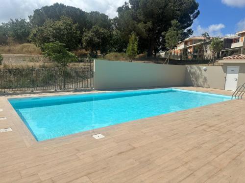une piscine avec de l'eau bleue dans une cour dans l'établissement Domaine Eden Golfe 215, à Cogolin