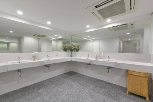 a bathroom with a row of sinks and mirrors at Tiang Capsule in Bangkok