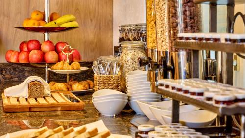 a buffet with fruit and other food on a counter at Hotel Linderhof in Erfurt