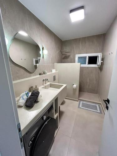 a bathroom with a sink and a washing machine at La Esquina Central in Iraklitsa