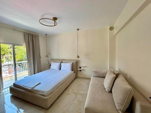 a bedroom with a large bed and a couch at La Esquina Central in Iraklitsa
