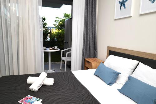 a bedroom with a bed and a balcony with a table at La Scala Nikiti in Nikiti