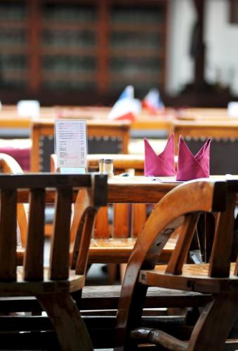 a wooden table with pink napkins on top of it at Maeyom Palace Hotel in Phrae
