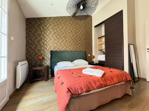una camera da letto con un letto grande con una coperta rossa di Jolie Maison La Havane avec terrasse plein sud a Vichy