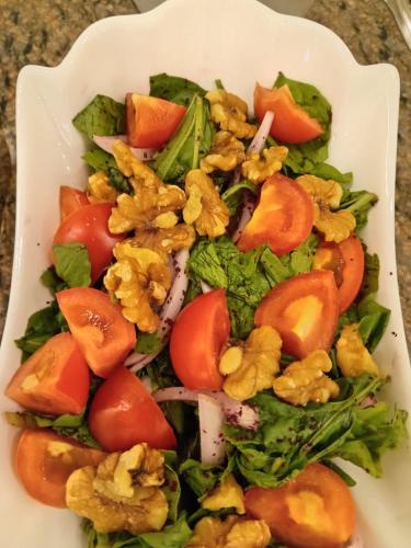 a plate of salad with tomatoes broccoli and other vegetables at Petra Premium Hotel in Wadi Musa