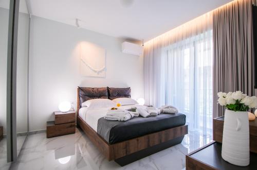 a bedroom with a bed and a large window at Oikos luxury central apartment in Agios Nikolaos