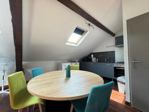 une cuisine avec une table en bois et des chaises vertes dans l'établissement Le Loft - Palm Strings tout confort 6personnes, à Vichy