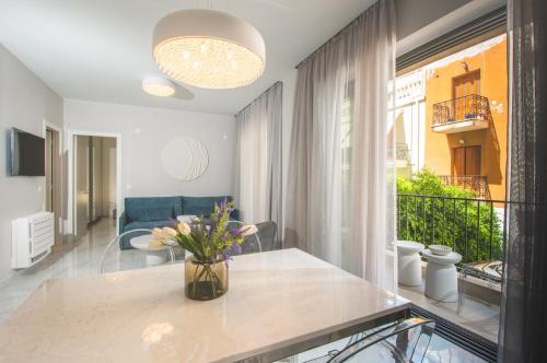 a living room with a vase of flowers on a table at Oikos luxury central apartment in Agios Nikolaos