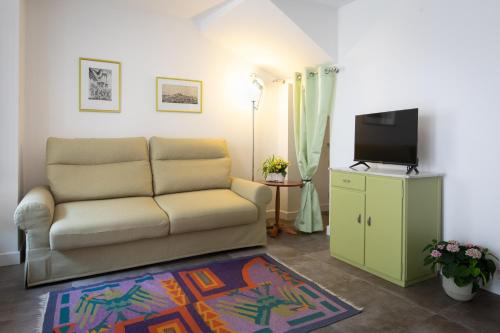 a living room with a couch and a flat screen tv at Ai Priori in Gemona del Friuli