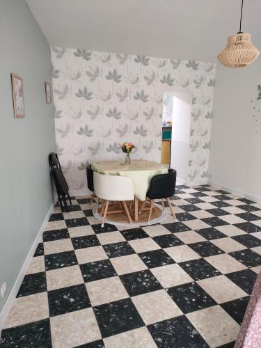 - une salle à manger avec une table et un sol en damier dans l'établissement Jolie maison, à Vaas