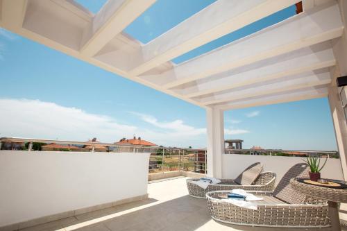 balcone con sedie in vimini e vista sull'oceano di Marane a Paralia Dionysiou