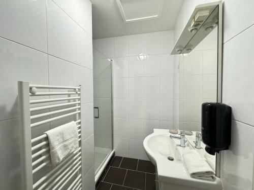 une salle de bain blanche avec un lavabo et une douche dans l'établissement Bel appartement Agadir pour 6 personnes, à Vichy
