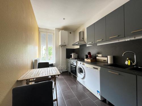 une cuisine avec lave-linge, sèche-linge et une table dans l'établissement Bel appartement Agadir pour 6 personnes, à Vichy