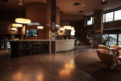 a restaurant with a bar and chairs in a building at Hotel City Maribor in Maribor