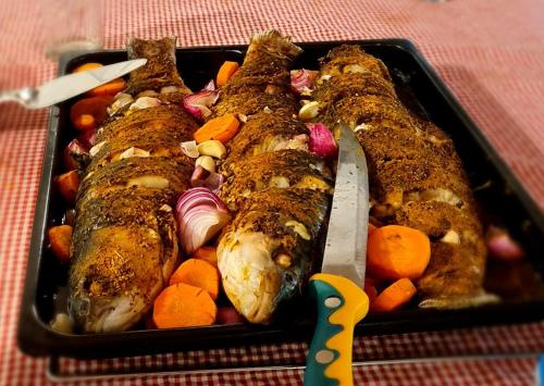 a tray of food with fish and vegetables and a knife at The Lodge Digana in Digana