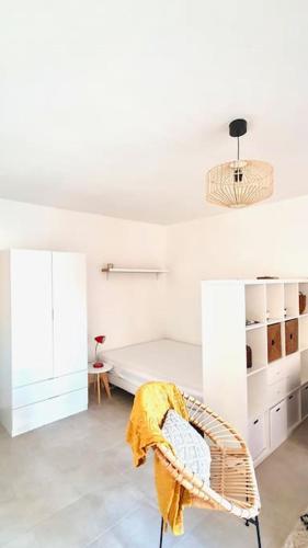 une chambre blanche avec un lit et une chaise dans l'établissement Cosy Studio nice proche tram parking prive, à Nice