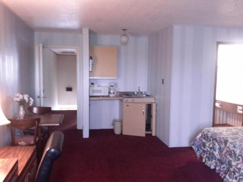 a room with a kitchen and a bed and a table at Diamond Motor Inn in Owen Sound