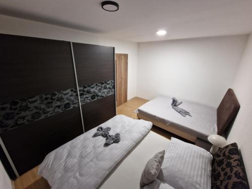 斯塔利斯莫克维克Suterénový Apartmán Starý Smokovec的有两张床和一张桌子的小房间