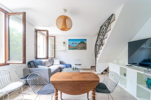 a living room with a couch and a table at Le Duplex de Drancy - Appt 5p à 25 min de Paris in Drancy