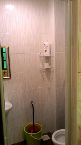 a bathroom with a toilet and a bucket at Fastbook Sun Moon City Home 12Pax in Ayer Itam