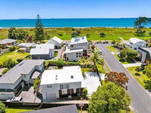 an aerial view of a town with white houses at Beauty by the beach in Papamoa