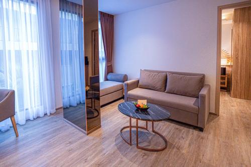 a living room with a couch and a table at The Marin Phuket Kamala Beach in Kamala Beach