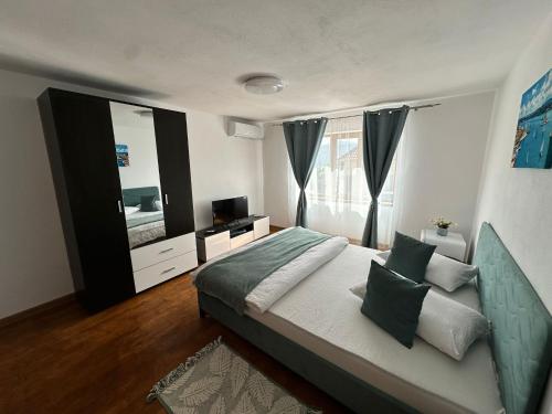 a bedroom with a large bed and a television at Casa Ilici in Sviniţa