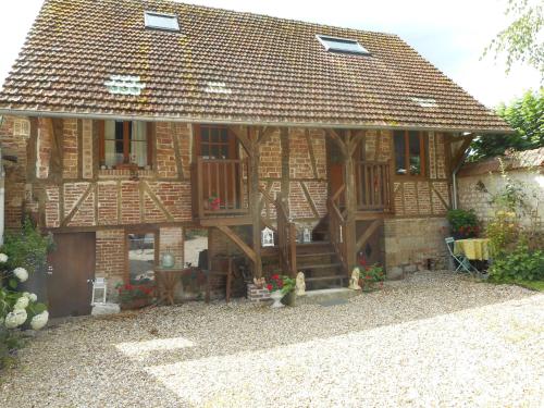 a brick house with a porch and a patio at Le Gite de Lili in Acquigny