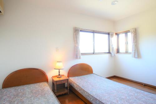 a bedroom with two beds and a window at Farm Inn Minamiboso in Minamiboso