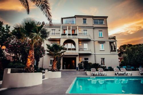 a large house with a swimming pool in front of it at Hotel Benaco in Desenzano del Garda