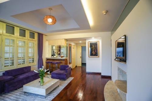 a living room with purple couches and a table at TTC Hotel - Ngoc Lan in Da Lat