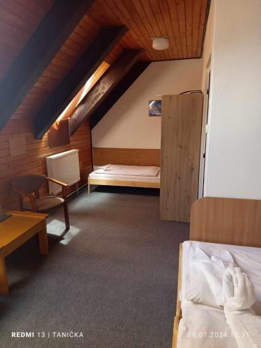 a attic room with a bed and a desk at Penzión Zátoka in Liptovský Mikuláš