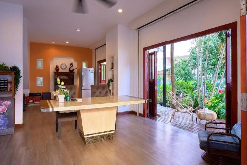 a kitchen with a large wooden table in a living room at Jinta Andaman in Kata Beach